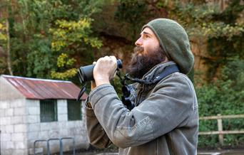 A bearded birdwatcher with his binoculars at the Old Town Quarry, Weston-super-Mare