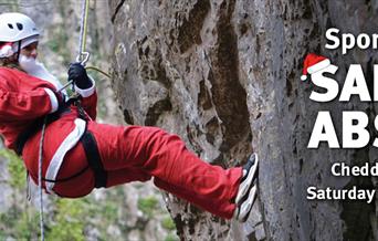 Santa abseiling down a rockface