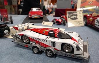 A picture of a red and white model racing car on a model trailer to advertise a model show at the Weston-super-Mare Helicopter Museum