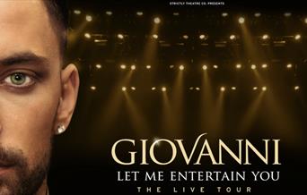 Gionvanni facing the camera with spotlights behind hm.