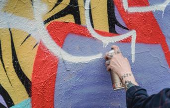 Person with spray can performing street art