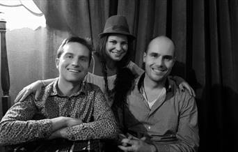 Black and White image of 3 band members looking to camera