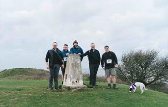 Five men at Sand Point, one with a dog on a lead