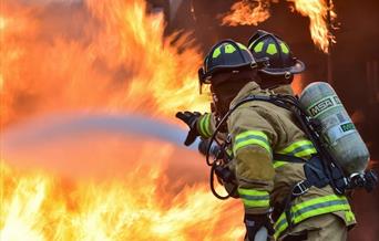 Two firefighters tackling flames