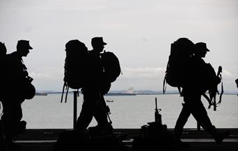 Silhouette showing military servicemen with their backpacks