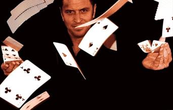 Poster of Richard Griffin, Magician, against a black backdrop and cards flying through the air.