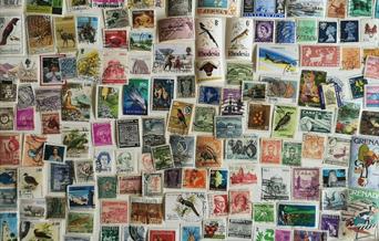 Photograph of stamps from all over the world in various colours and sizes.