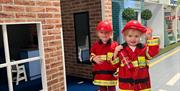 Two children in red playing doctors