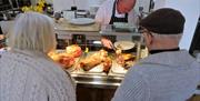 A chef serving two people a carvery