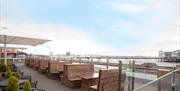 Outside seafront bar with high-backed wooden bench tables