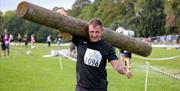 Competitor carrying a large log on his shoulders