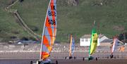 Four land yachts racing cross the sand at Brean Beach