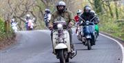 A procession of Vespa-style scooter riders on their ride-out from Weston-super-Mare