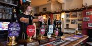 A barman pulling a pint in a pub