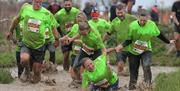 A team in an action race help their female colleague who has fallen in the river they are running through