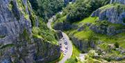 View from the top of a gorge looking down at the road and cars below