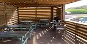 Covered wooden outdoor dining area with long outdoor bench tables at the Sand Bay Fish & Chip shop