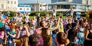 Two musicians playing their brass instruments while being in the middle of a crowd