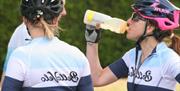 Ladies in cycle helmets drinking water