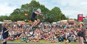 A mountain bike stunt rider jumping over a tightrope