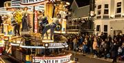 A Hollywood-themed carnival float with dancing performers on it at the Weston-super-Mare carnival