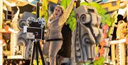 An enthusiastic female character standing next to an old film camera on a brightly-coloured Hollywood-themed carnival float at the Weston-super-Mare c