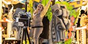 An enthusiastic female character standing next to an old film camera on a brightly-coloured Hollywood-themed carnival float at the Weston-super-Mare c