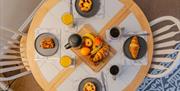 An aerial view of a round breakfast table set with croissants, fruit and orange juice at the Seaside Apartments, Weston-super-Mare