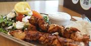 Food platter with meat skewers and a salad