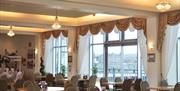 Interior of an empty restaurant with tables and plush curtains