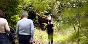 A family of three walking through woods