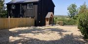 Outside view of a black wooden house and a shingle drive