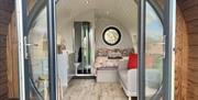 Looking through a round window at the interior of a glamping pod