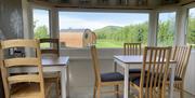 Interior of a dining room with wooden chairs set around two white tables