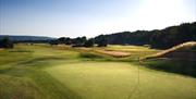 A golf hole with sunshine overlooking a bunker