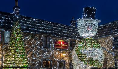 The Queen Victoria pub in Priddy and its famous Christmas Lights display featuring a giant 26ft tall snowman made out of 2,500 empty wine bottles and