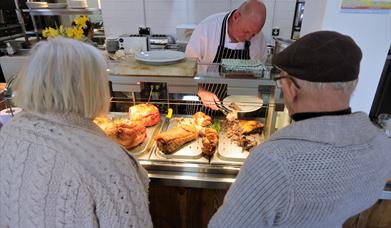 A chef serving two people a carvery