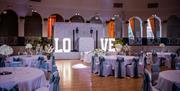 A ballroom set out for weddings with the word Love spelt out on the stage