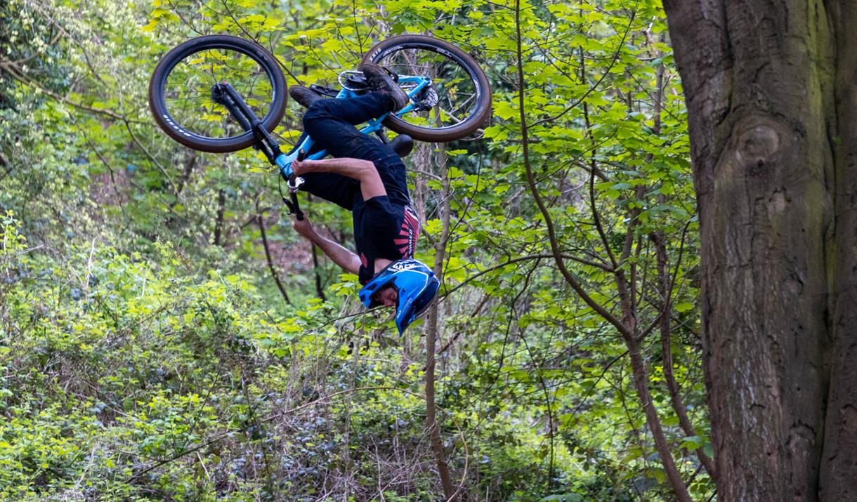 Bike rider upside-down as he tackles one of the jumps at the Sand Bay Dirt Jump track at Kewstoke