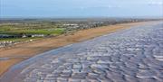 Looking down on the sandy Brean beach as waves lap the shoreline