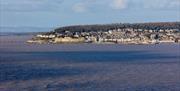 Looking across a bay to Weston-super-Mare town with woods behind