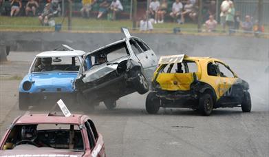 A banger racing car sandwiched between two other banger racing cars