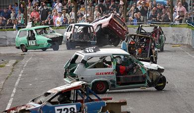 A race track is left strewn with banger racing cars crashing into each other