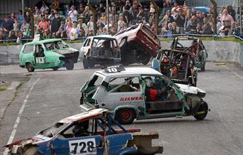 A race track is left strewn with banger racing cars crashing into each other