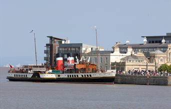 A paddle steamer docked in a harbour