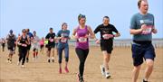 Race runners running on a sandy beach