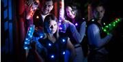 Group of four people holding illuminated laser guns