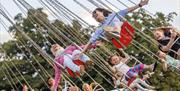 Children on fairground rides at Bristol Balloon Fiesta