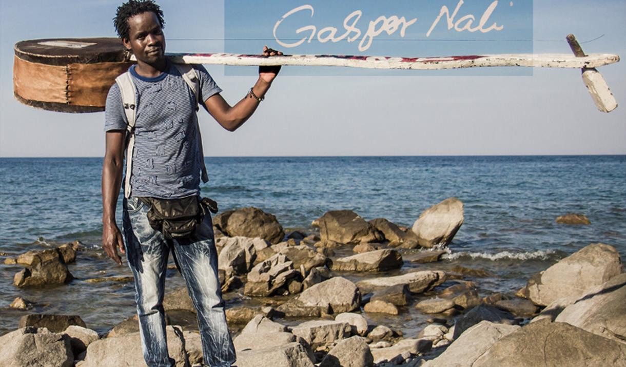 Gaspar Nali on rocky beach with percussion instrument