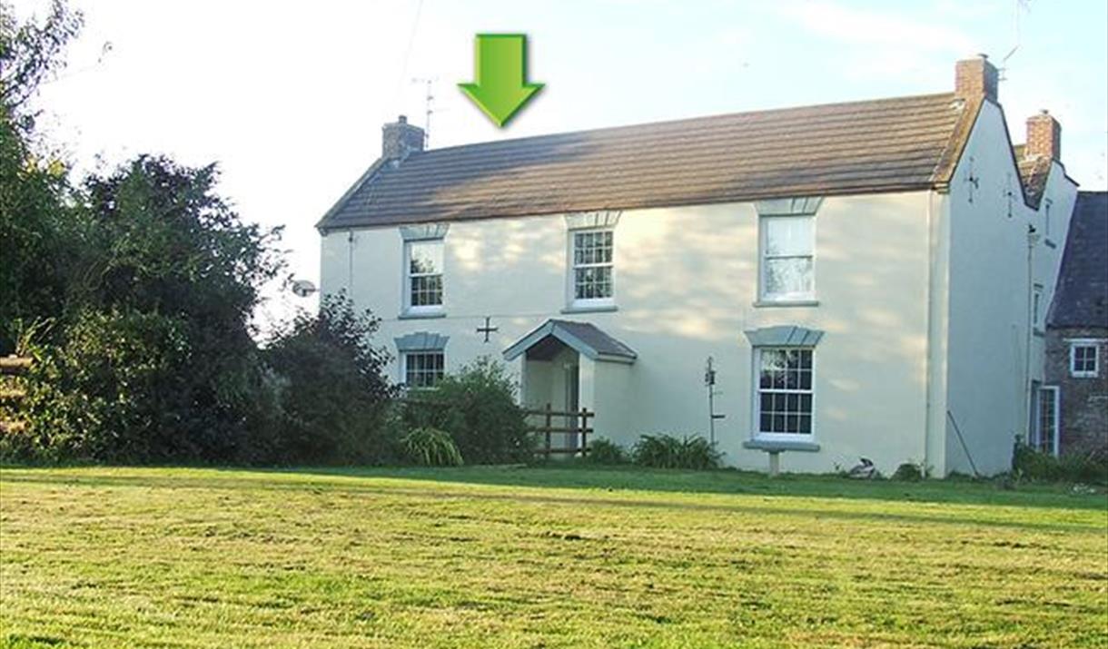 Exterior of the property marked with a green arrow showing which section is Hideaway